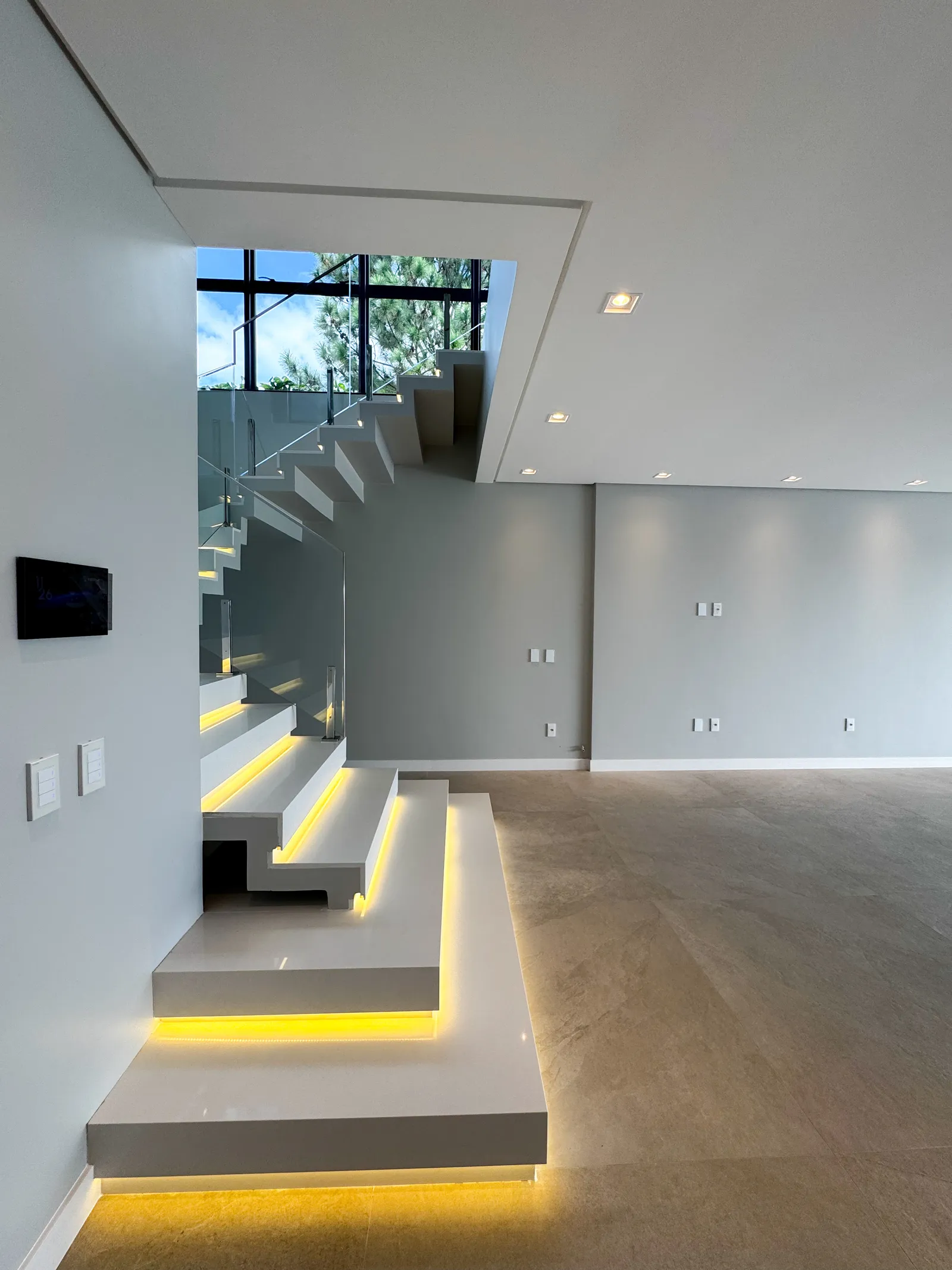 Escada interna em mármore branco com iluminação embutida nos degraus