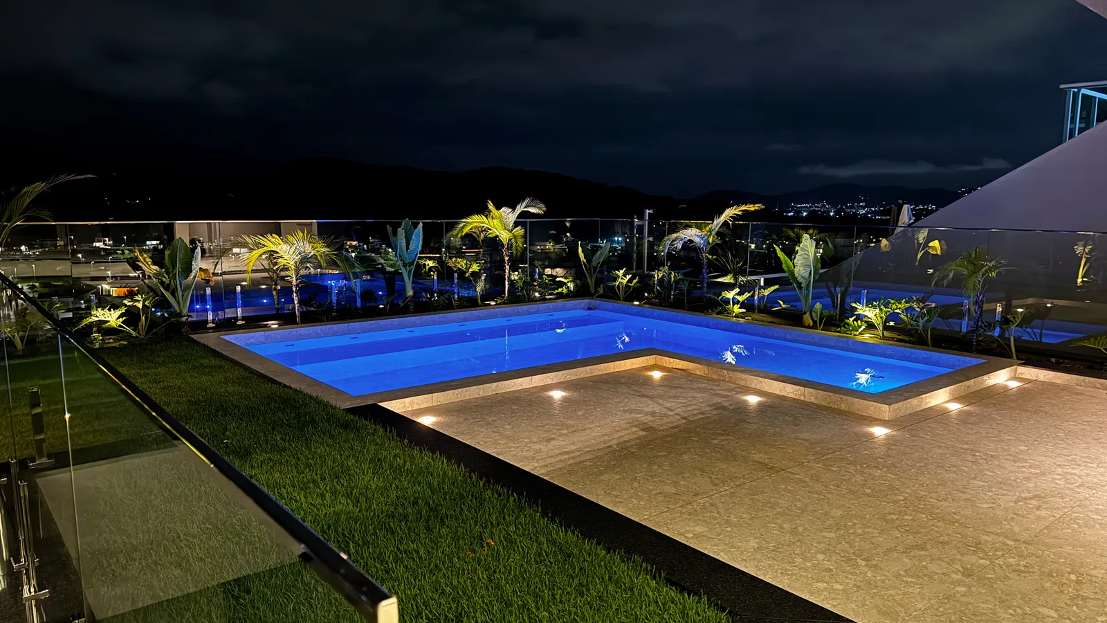 Piscina e terraço da Casa Van Gogh à noite, com vista para as luzes da cidade